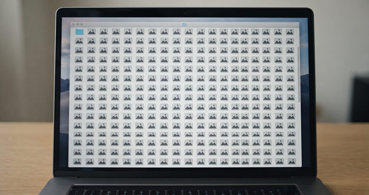 ノートパソコンの画面に、フォルダの中に正方形の画像アイコンがグリッド状に整然と並んでいる様子